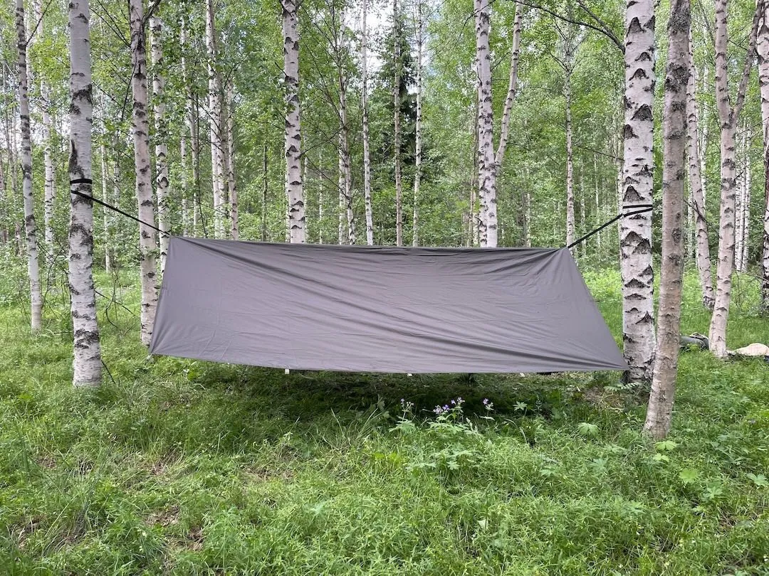 Jord Asym Tarp pitched over a hammock in the forest