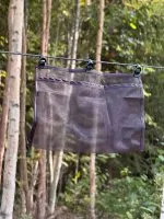 Mesh hammock pocket hung from a line between trees