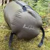 Olive 36 litre compression sack with the Momo Jord logo